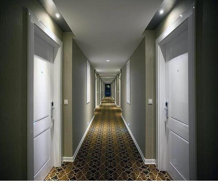 The hallway of a hotel is shown