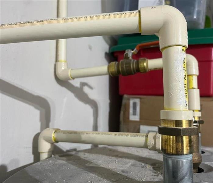 New pipes on top of a water heater are shown