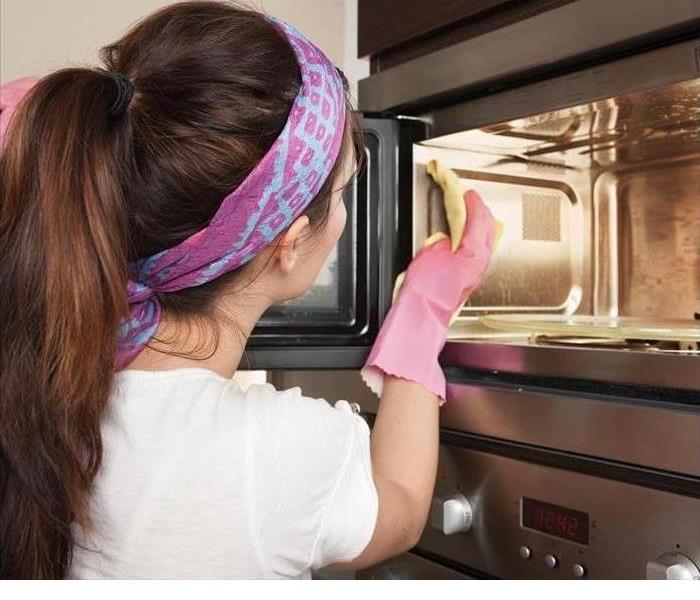 A woman is shown cleaning a microwave