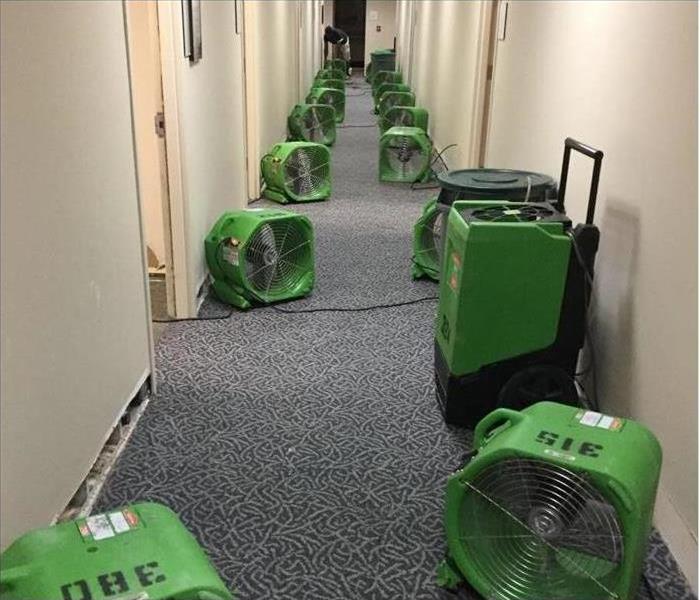 Air movers and dehus set up in commercial building hallway